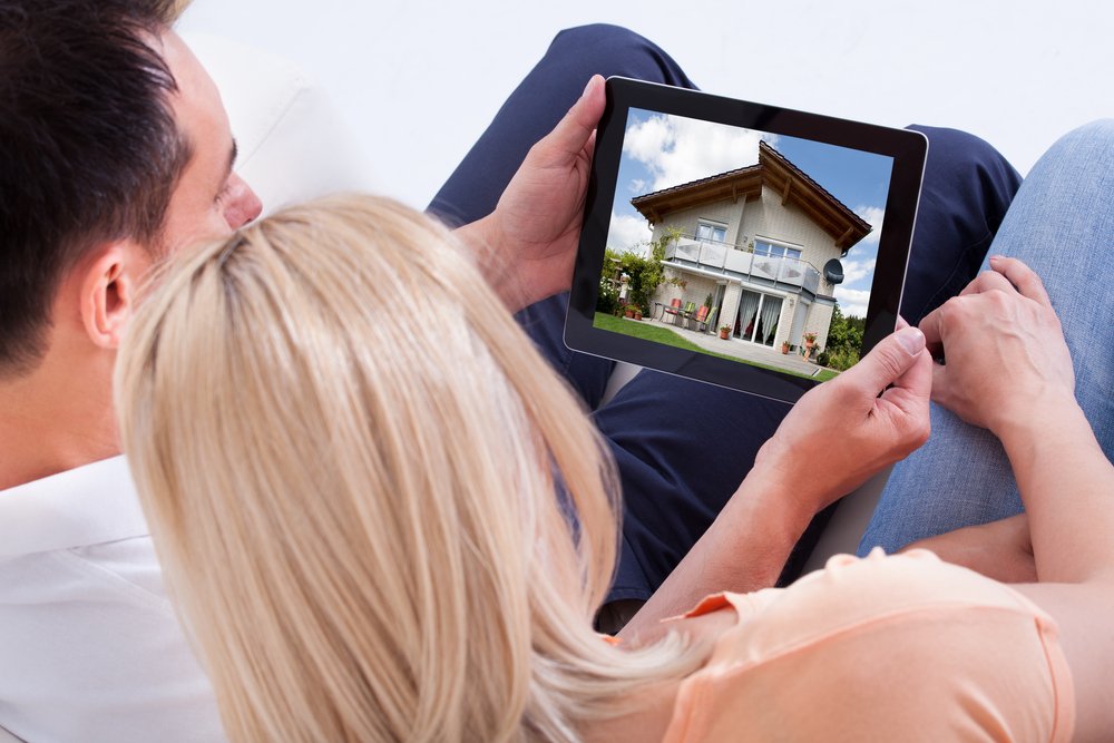 Couple,Looking,At,House,On,Digital,Tablet's,Screen