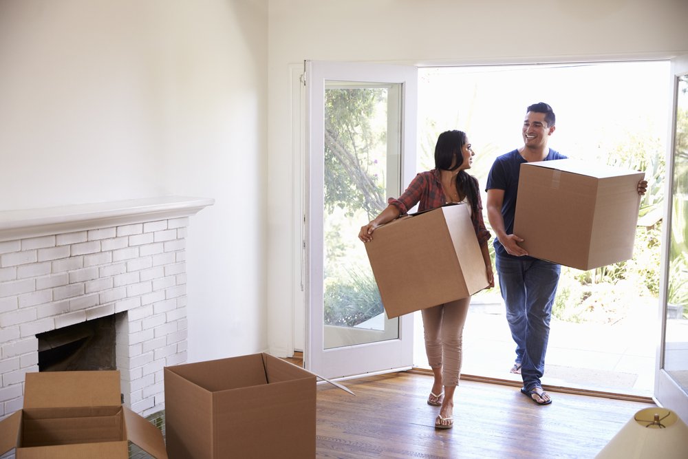 Couple,Carrying,Boxes,Into,New,Home,On,Moving,Day